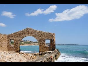a stone building on the beach near the water at Appartamenti Sul Mare in Avola