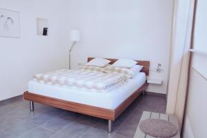 ein Schlafzimmer mit einem großen Bett mit einem Holzrahmen in der Unterkunft Alte Schmiede in Weisweil