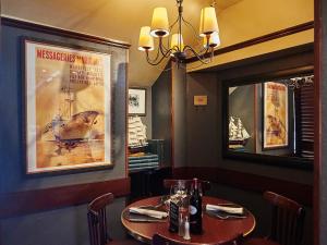 a dining room with a table and a large mirror at Au Relais Nivernais in Nevers