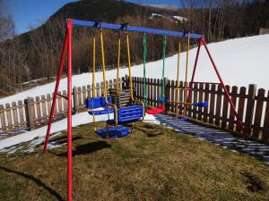 a playground with swings in the snow at Ferienhaus Almfrieden in Schladming