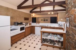 a large kitchen with white appliances and wooden cabinets at Trastevere Cowaramup Farm House in Cowaramup