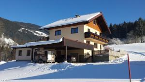 a house with snow on the ground in front of it at Ferienhaus Almfrieden in Schladming