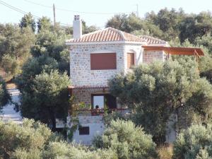 a house on the side of a hill with trees at Villas Zoe in Skiathos