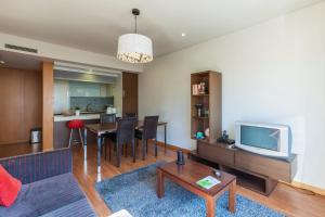 een woonkamer met een tafel en een televisie bij Onice Apartment in Porto