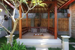 een bed onder een paviljoen met een persoon erop. bij Ananda Private Villa in Gili Trawangan