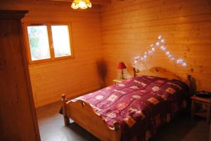 1 dormitorio con 1 cama en una cabaña de madera en Christelle et Laeticia, en Gérardmer