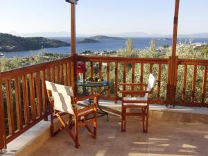 a balcony with two chairs and a table with a view at Villas Zoe in Skiathos +19 photos