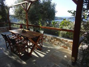 a wooden table and chairs on a patio with a view at Villas Zoe in Skiathos