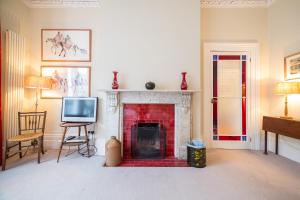 un salon avec une cheminée et une télévision dans l'établissement The Bockery Suite 1 Chelsea, à Londres