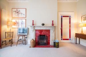 ein Wohnzimmer mit einem Kamin und einem TV in der Unterkunft The Bockery Suite 1 Chelsea in London