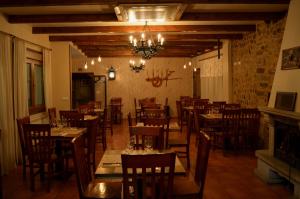a restaurant with wooden tables and chairs and a chandelier at Hotel Casa Reboiro in Monforte de Lemos