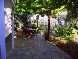 a patio with a table and chairs under a tree at Villas Zoe in Skiathos