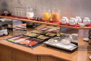 ein Buffet mit Sushi und anderen Speisen und Getränken in der Unterkunft Hotel Zur Sonne in Waren (Müritz)
