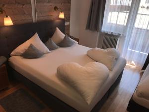 a bed with a heart shaped pillow on it at Clubdorf Hotel Alpenrose in Galtür