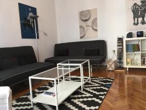 uma sala de estar com um sofá preto e uma mesa de café em vidro em Main Square Apartment em Zagreb