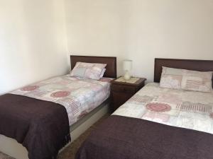 two beds sitting next to each other in a bedroom at Bay House in Lambertʼs Bay