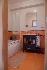 a bathroom with a tub and a sink and a mirror at Apartamento Urbanização Aurora Rio in Vila Real de Santo António
