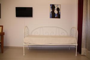 un banco blanco en una habitación con TV de pantalla plana en Apartamento Urbanização Aurora Rio en Vila Real de Santo António