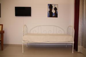 a white bench in a room with a flat screen tv at Apartamento Urbanização Aurora Rio in Vila Real de Santo António