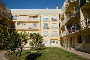 an apartment building with trees in front of it at Apartamento Urbanização Aurora Rio in Vila Real de Santo António