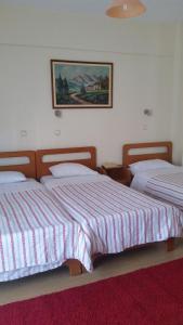 1 dormitorio con 2 camas y una foto en la pared en Filareti Hotel, en Florina