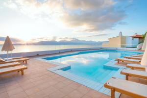 
a pool with a pool table and chairs in it at Miramare Resort & Spa in Agios Nikolaos
