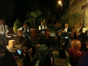 a group of people sitting around a stage with music at Hôtel des Barrages in Brommat
