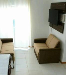 sala de estar con 2 sofás y TV en Apartamento linda vista para o mar Penha Parque Beto Carrero, en Penha