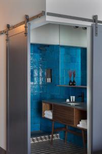 uma casa de banho com um chuveiro com azulejos azuis em The Hotel Salem em Salem
