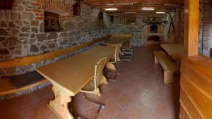 una fila de mesas y bancos de madera en un edificio en Apartments Šuster, en Stari Trg ob Kolpi
