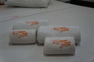 four stacks of white towels with red writing on them at Pousada Rozam in Olímpia