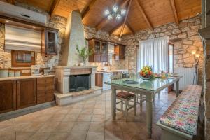 a kitchen with a table and a stone wall at Tramonto Villa in Volímai