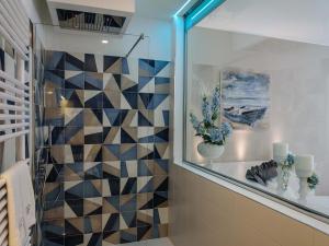 a bathroom with a mosaic tile wall at Bellariva Monopoli B&B e Relax in Monopoli +37 photos