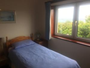 1 dormitorio con cama y ventana en Invernettie guesthouse, en Peterhead