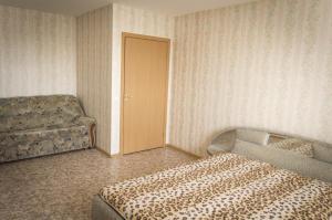 オレンブルクにあるApartment on Amurskaya 8のベッドルーム1室(ベッド1台、椅子1脚、ドア付)
