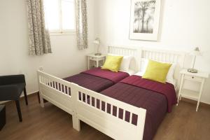 1 Schlafzimmer mit 2 Betten mit lila und gelben Kissen in der Unterkunft Casa Aiora in Adamas