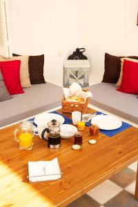 a living room with a coffee table with plates and orange juice at Casa Aiora in Adamas