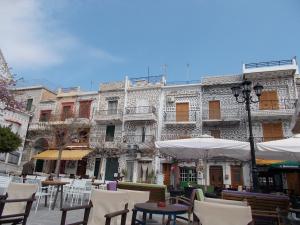 an outdoor patio with tables and chairs and a building at Traditional Guest house Chrisyis in Pyrgi