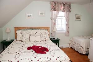 ein roter Teddybär auf einem Bett im Schlafzimmer in der Unterkunft Candlebay Inn in Freeport