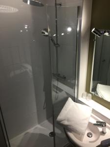 um chuveiro com uma porta de vidro ao lado de um lavatório em Sweet Home em Belley
