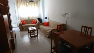 un soggiorno con divano e tavolo di Apartment La Huerta de Beniajan 50 por ciento dcto directo a Murcia