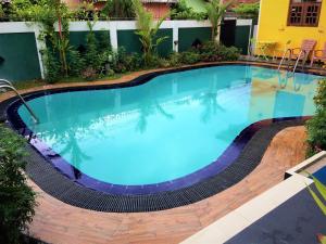 a large swimming pool with blue water in a building at Romeo and Juliet Guest House in Negombo