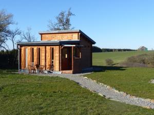 a tiny house in a field with a gravel path at Chalets am National Park Eifel in Schleiden