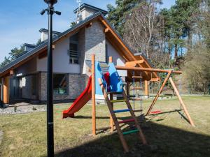 a playground with a slide in front of a house at Leśna7 in Sztutowo