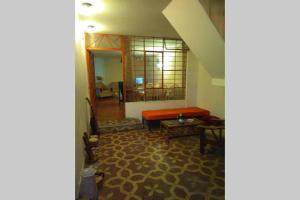 a living room with an orange couch and a table at Hospedaje Casa Viru in Lima