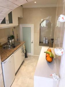 a kitchen with a sink and a bowl of fruit on a counter at AlfamaSweethome 2 in Lisbon