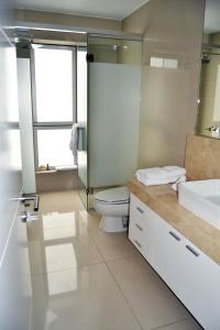 La salle de bains est pourvue de toilettes, d'un lavabo et d'une douche. dans l'établissement Departamentos Golf Park - Surco, à Lima