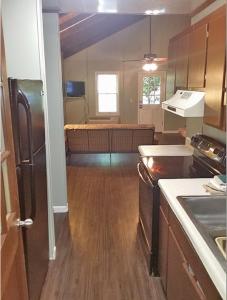 a kitchen with a stove and a refrigerator in a room at Carolina Landing Camping Resort Two-Bedroom Cabin 1 in Fair Play