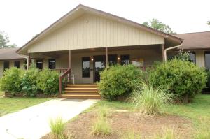 una casa con porche, escaleras y arbustos en Carolina Landing Camping Resort Two-Bedroom Cabin 1, en Fair Play