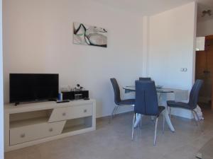 sala de estar con mesa con sillas y TV en Duplex 5 Mar de Plata, en Puerto de Mazarrón